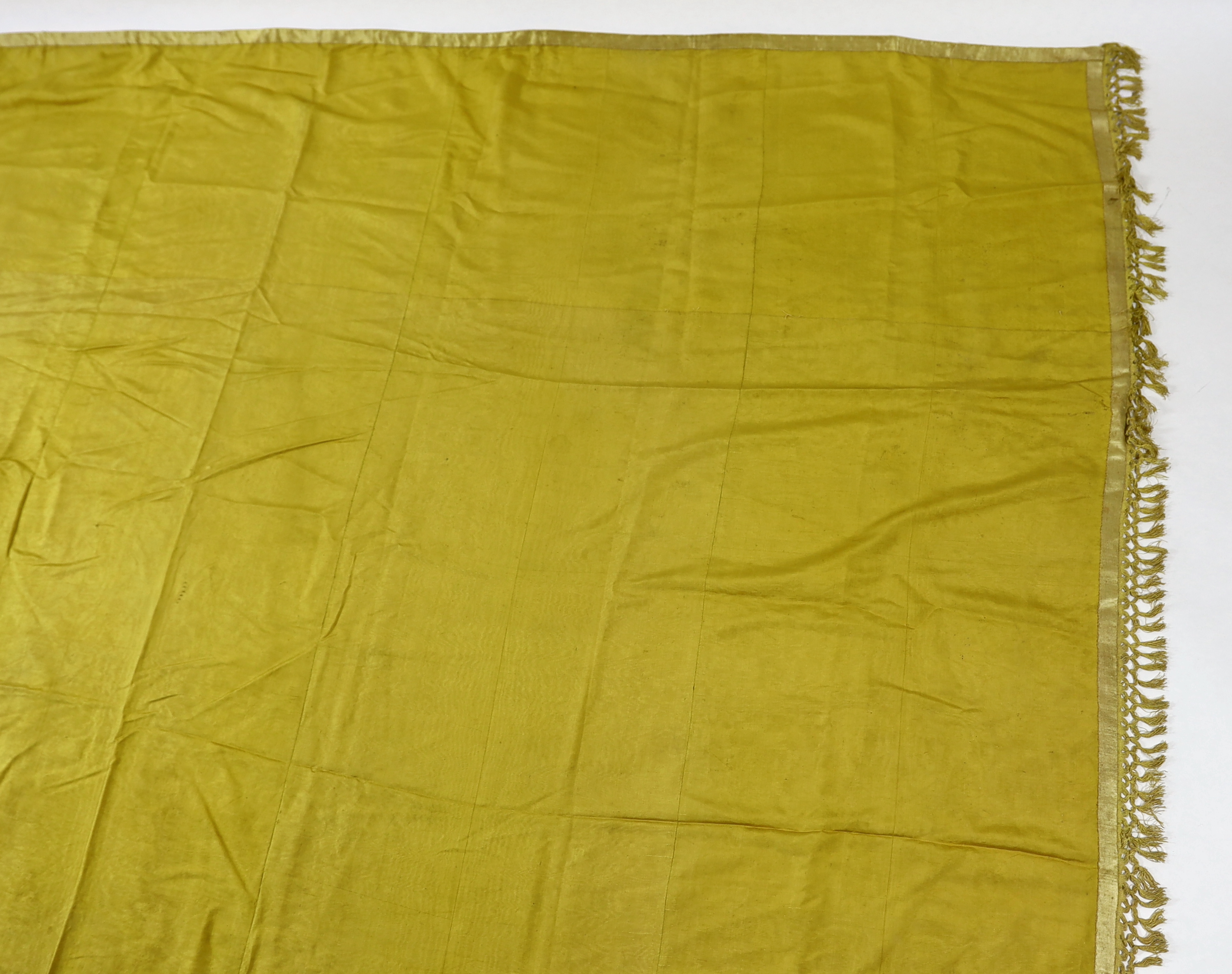 A large Regency yellow silk curtain, with fringed base, French short loom ribbed silk panels made into a wide curtain, with fringing on each side and at the bottom, 9ft wide x 8ft 6in. long